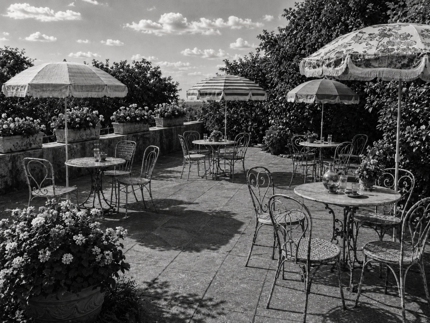 Linke Terrasse der historischen Gartenwirtschaft des Goldenen Ochsen mit Metallmöbeln, Sonnenschirmen und Blumenschmuck